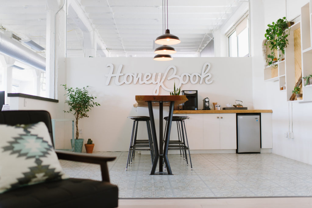 Honeybook Office kitchen with a counter top and the HONEYBOOK lettres in white. Out of focus couch on the left.